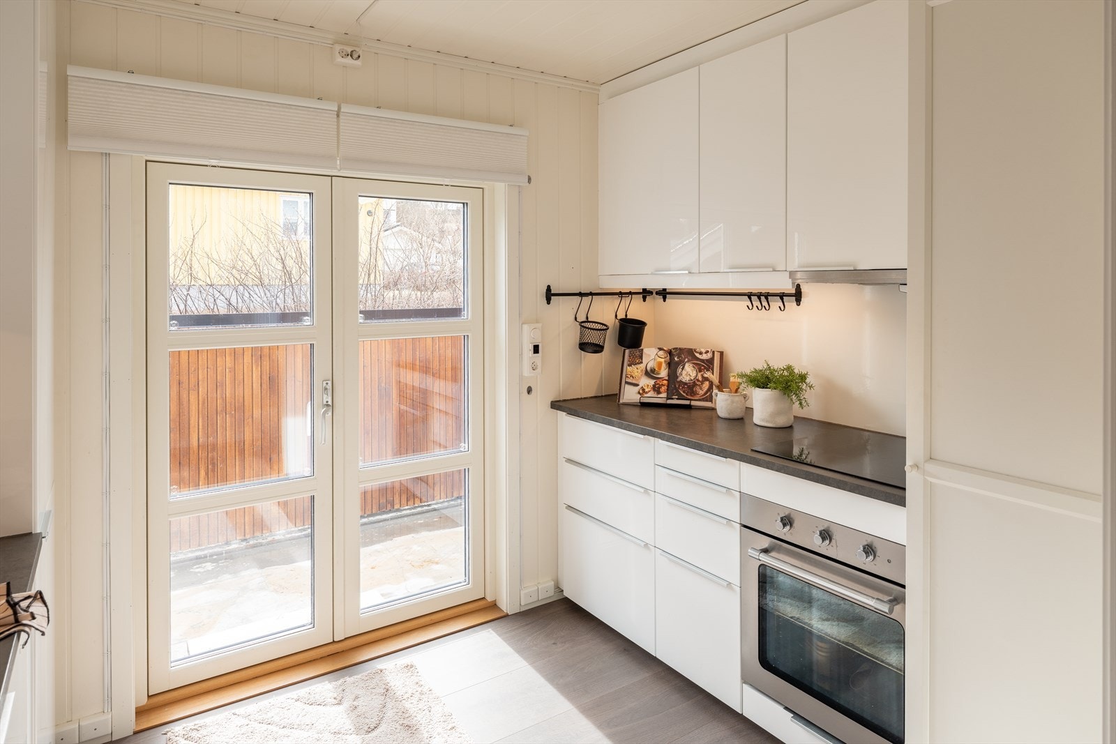 Fra kjøkkenet har man adkomst til enda et uteområde. Døren ut til dekket ble satt inn i 2022. Solskjerming følger handelen. Galleribilde