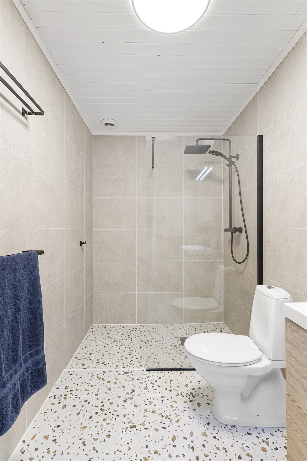 - Her er det baderomsplater på vegger og flis på gulv med moderne innredning - Galleribilde