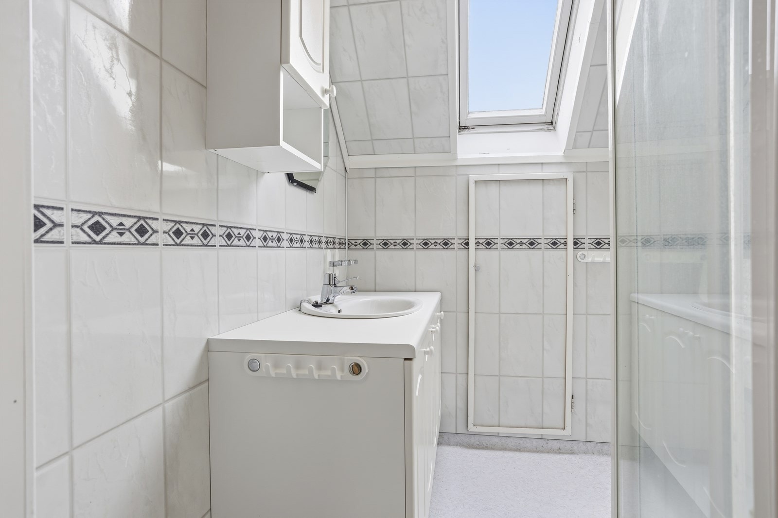 Badet på loftet er Lyst med baderomsplater, servant med underskap og dusjkabinett. Takvindu gir svært godt dagslys og en romslig følelse. Galleribilde