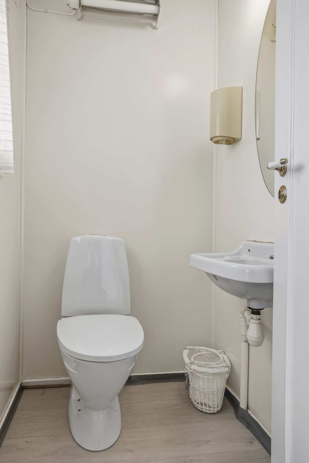 Praktisk toalettrom med gulvstående toalett og servant med speil. Galleribilde