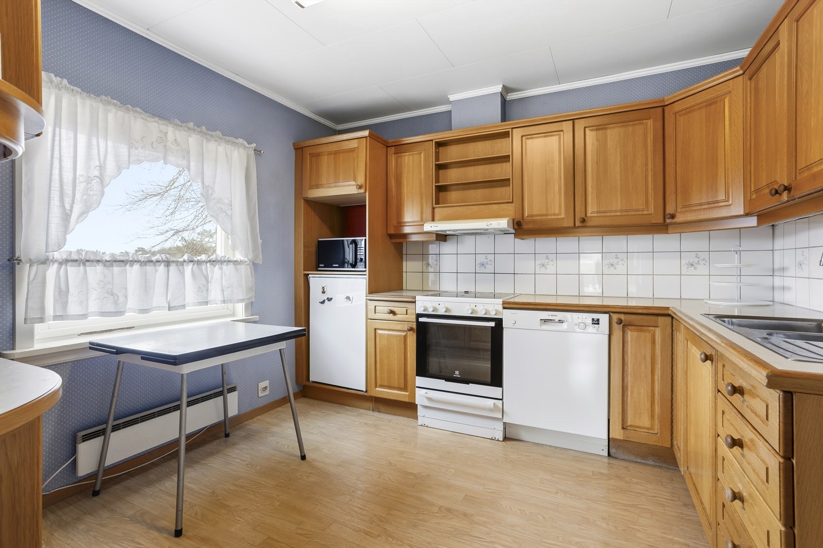 Her får du profilerte fronter og laminert benkeplate med nedfelt stålvask. Galleribilde