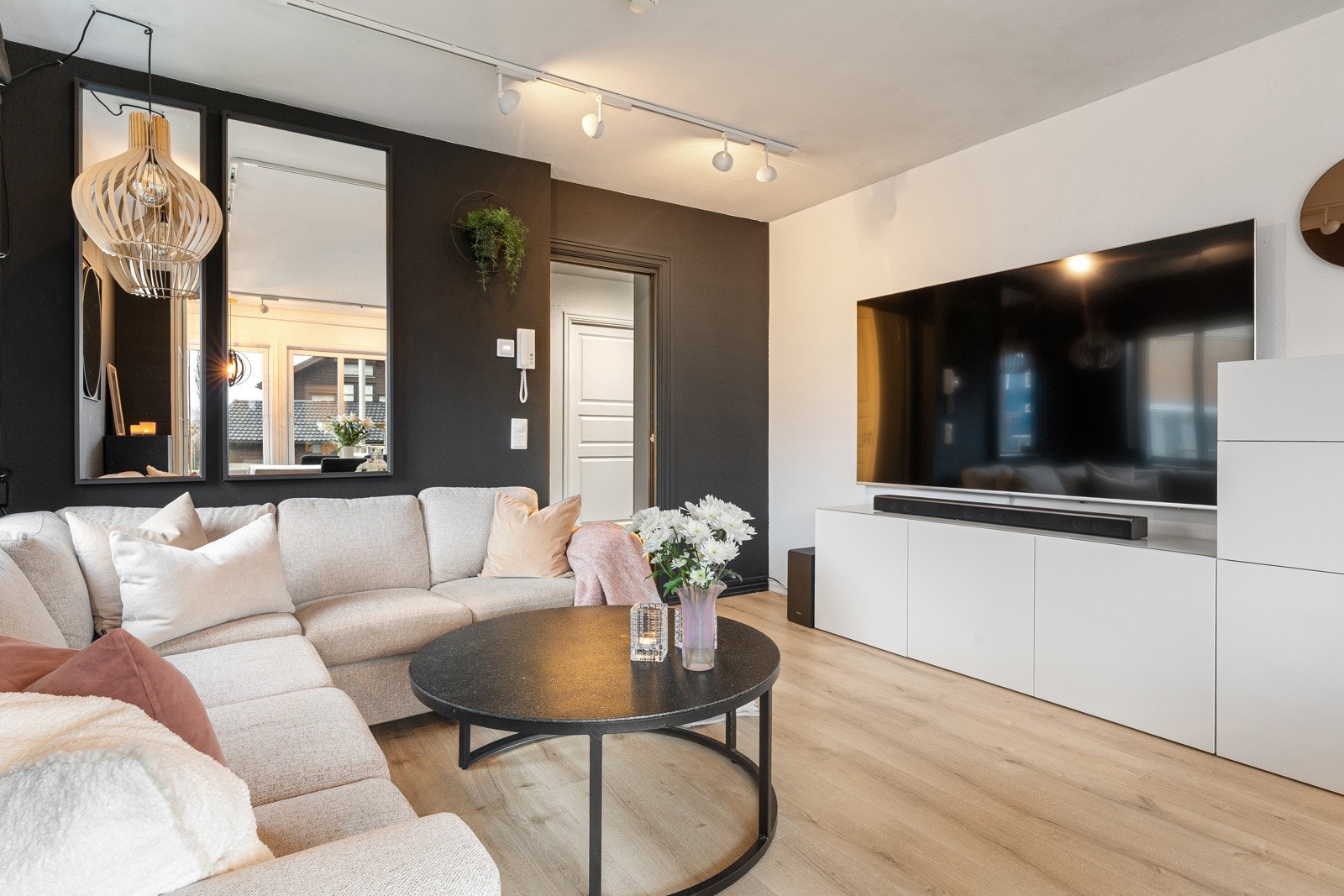 Åpen og innbydende stue med naturlige soner for bl.a. sofagruppe med TV på motsatt side.