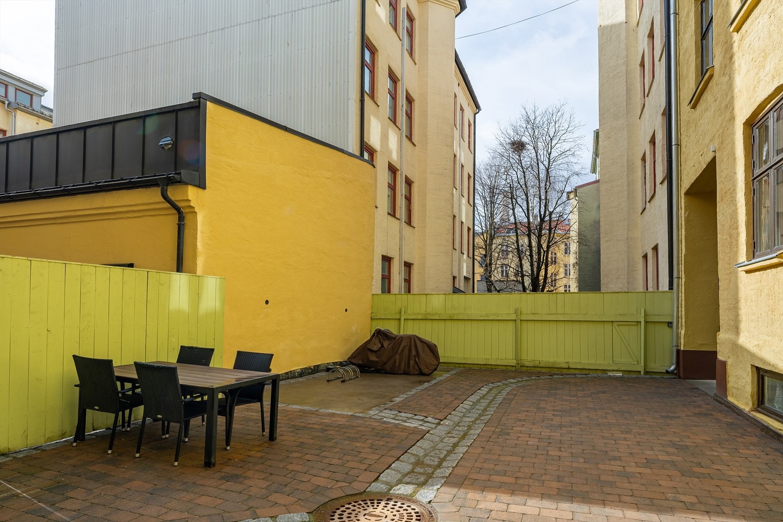 Bakgården har sykkelparkering og sittegruppe. På sommerstid pyntes i det i bakgården med diverse beplanting. Galleribilde