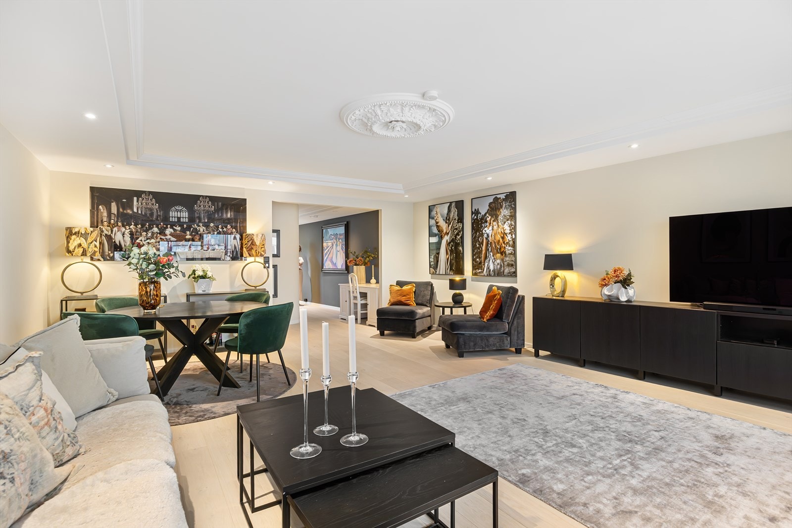 Rommet fremstår stilrent og harmonisk, og detaljer som klassisk takrosett og innfelte spotlights bidrar til et elegant uttrykk. Galleribilde