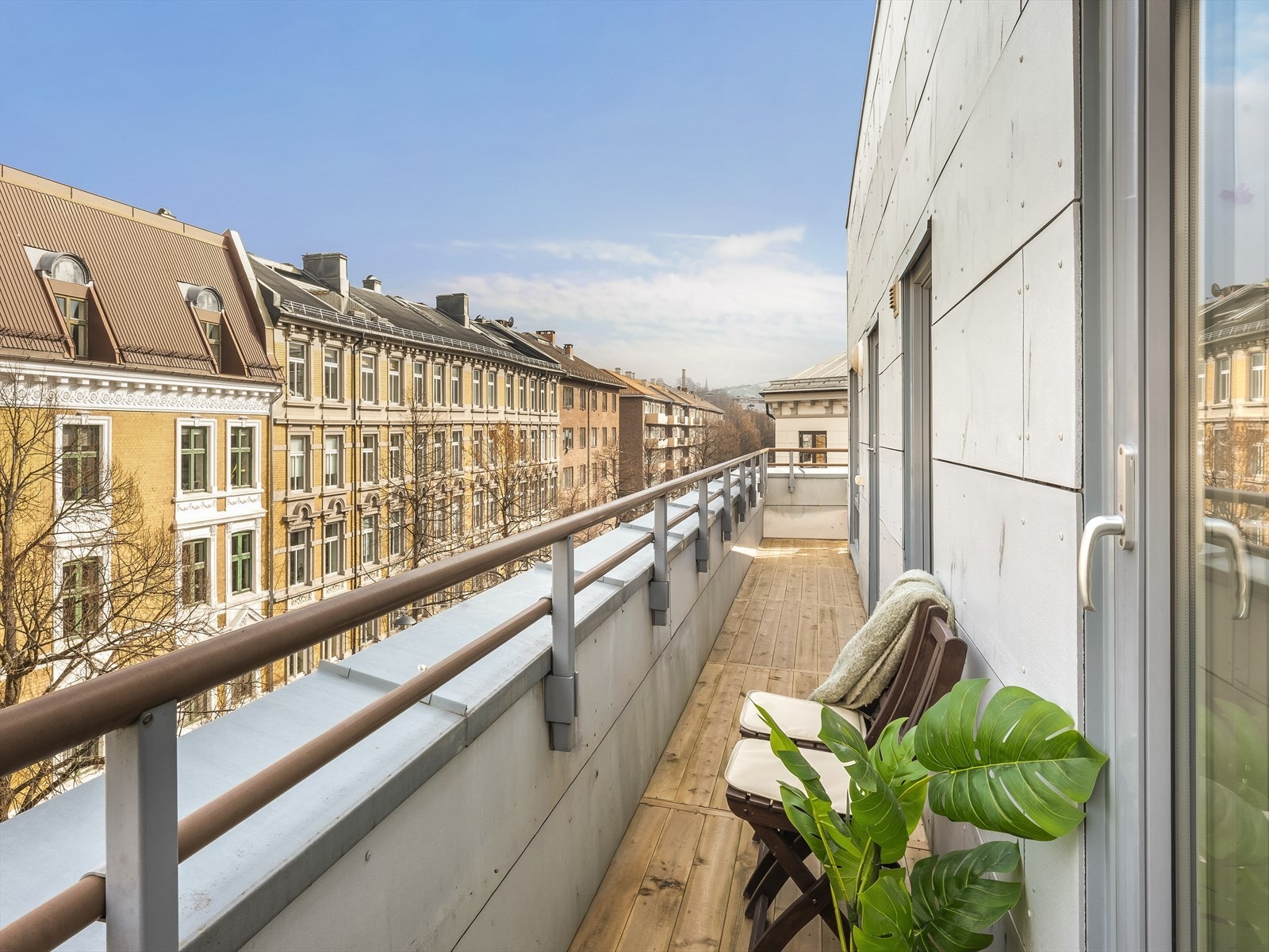 Den vinklede balkongen på 14 m² strekker seg langs leiligheten, med utgang fra både stue og soverom. Galleribilde