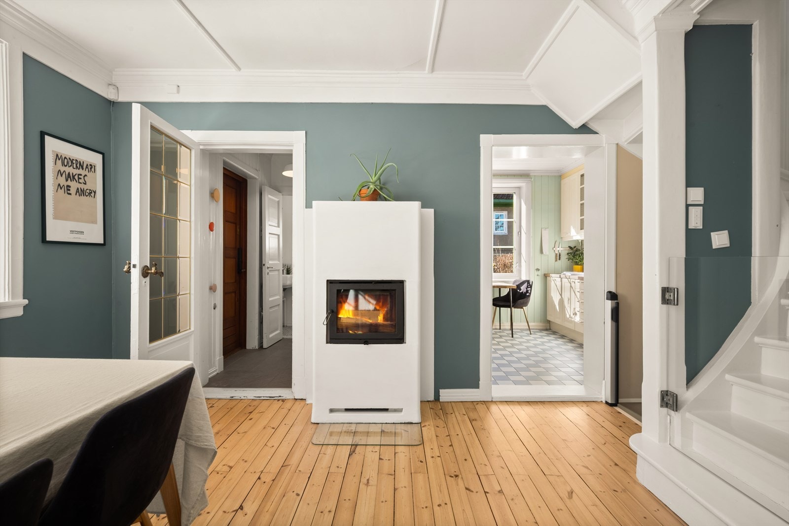 Midt i rommet står en hyggelig peisovn som varmer godt og skaper en god atmosfære Galleribilde