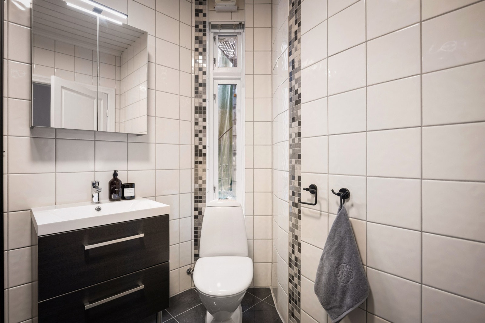 Badet inneholder servant med møblement/speilskap og belysning, overskap, toalett, dusjvegger i glass, dusjgarnityr og opplegg for
vaskemaskin Galleribilde