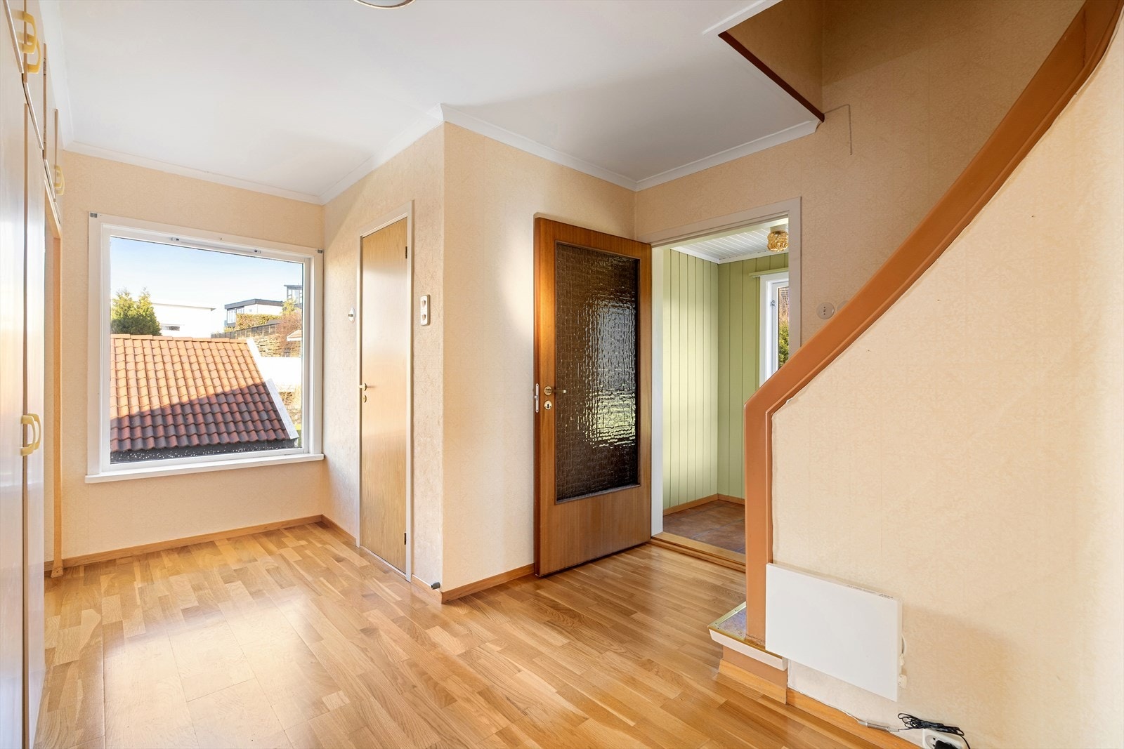 Fra entréen ledes man videre inn i en romslig gang med adkomst til trappeoppgang, oppholdsrom og bad. Galleribilde