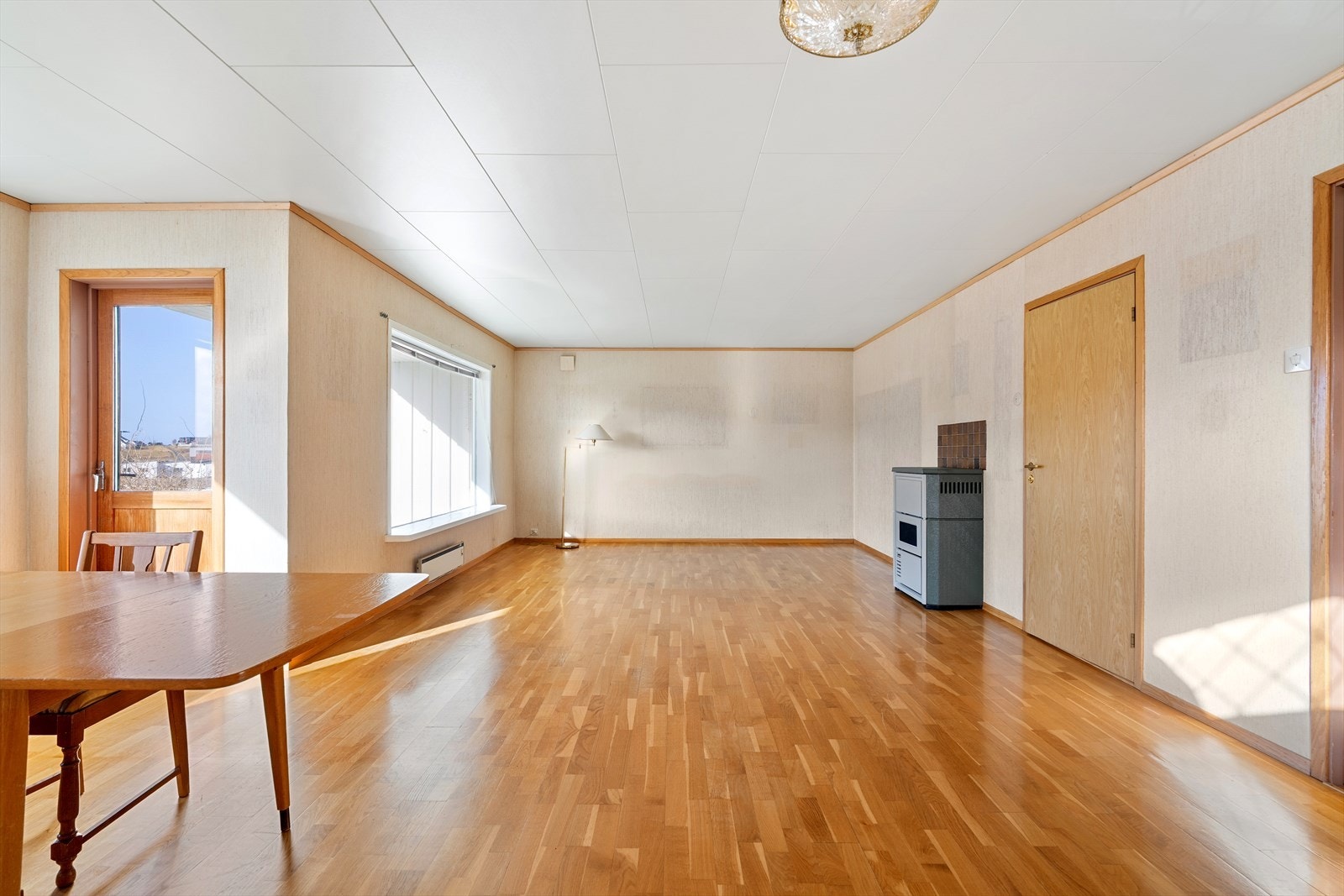 Stuen har ovn med oljekamin. Trestavs eikeparkett på gulv. Galleribilde