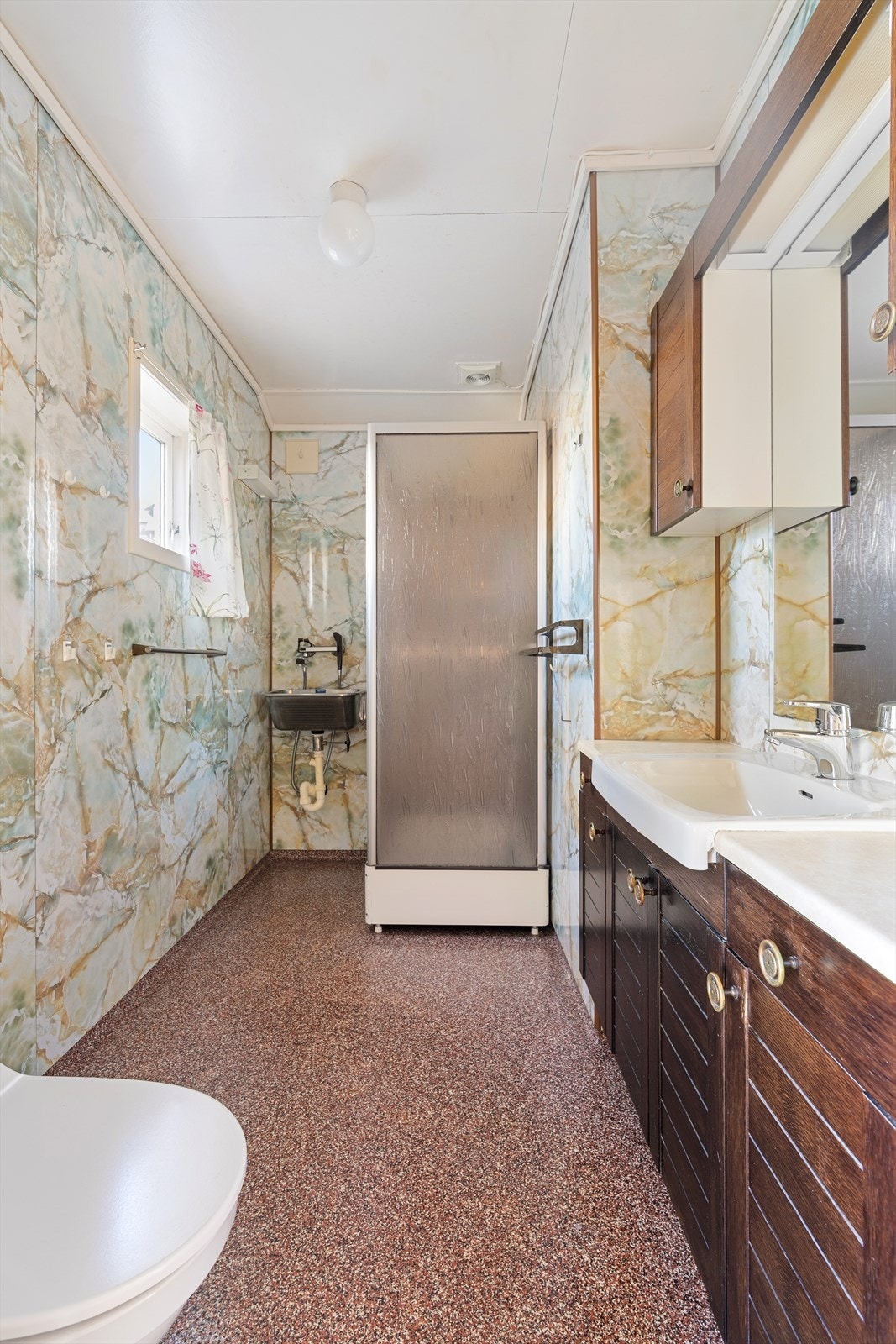 Badet er fra 1981 og er innredet med baderomsmøbel, toalett, utslagsvask og dusjkabinett. (Det foreligger ikke godkjente tegninger som viser utvidelse av bad) Galleribilde