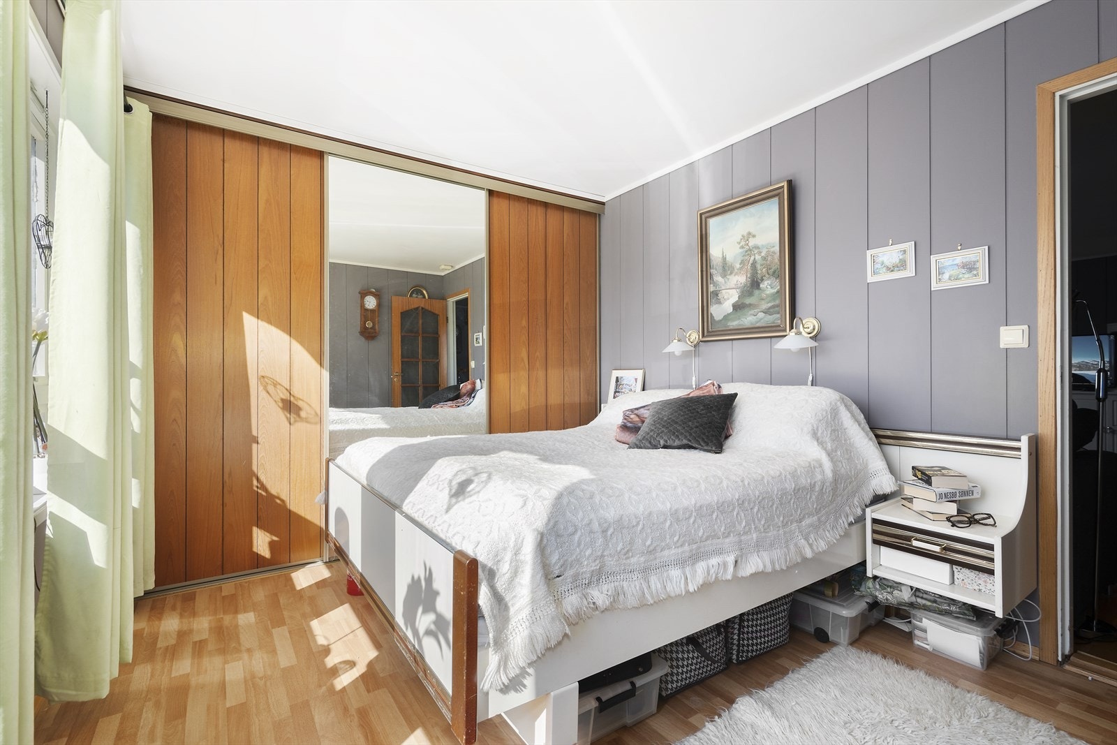 Langs vegg er det en skyvedørsgarderobe med delvis speilfront og glatte fronter Galleribilde