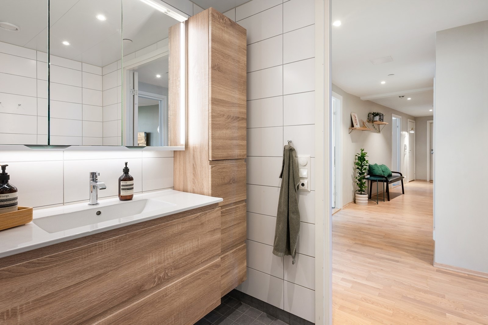 Flislagt gulv med varme, flislagte vegger og malt himling med downlights. Galleribilde