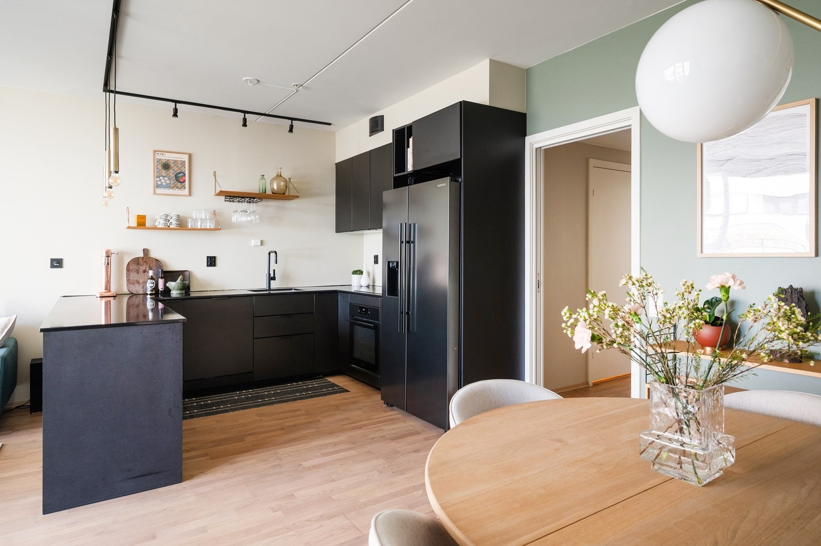 Romslig kjøkken med pen innredning fra 2020. Kjøkkenet har slette, lakkerte fronter, benkeplate i kompositt eller tilsvarende, underlimt oppvaskkum i rustfritt stål og ventilator med kullfilter. Galleribilde