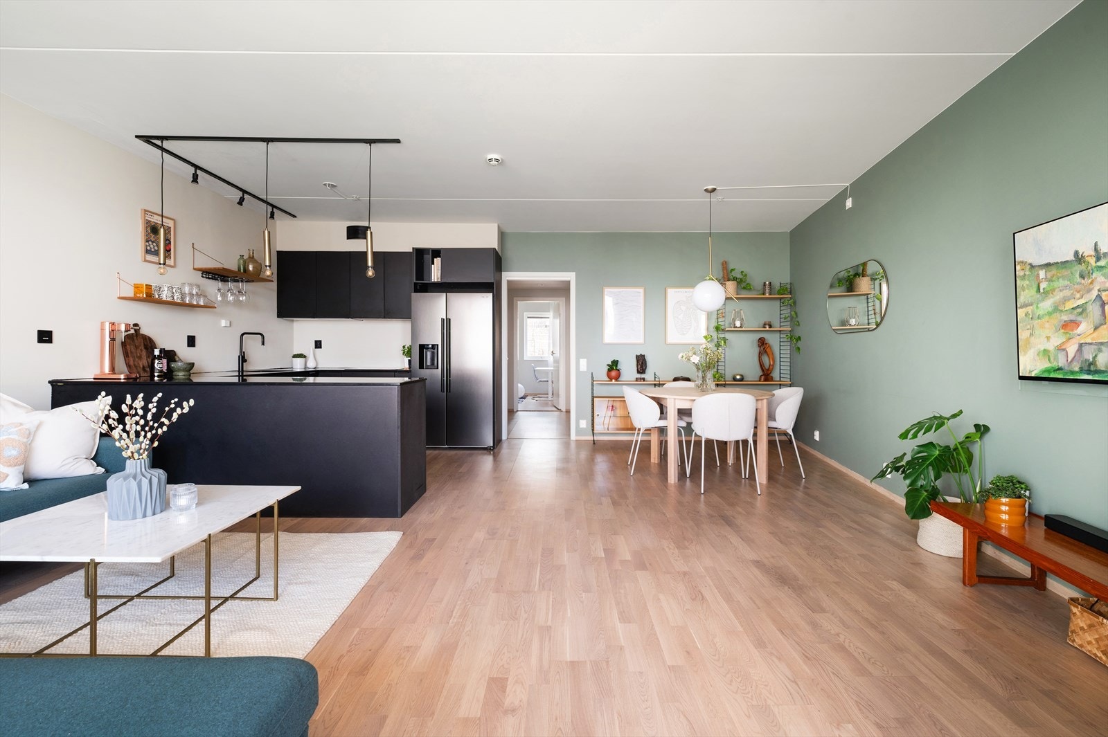 Stuen ligger i åpen løsning til kjøkkenet og bidrar til en luftig og sosial planløsning. Galleribilde