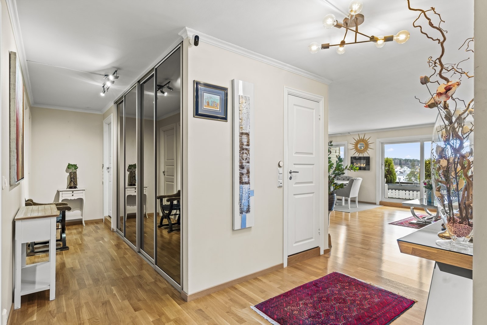 Leiligheten har en lys og innbydende entré med plass til å henge fra seg yttertøy i praktisk skyvedørsgarderobe med speilfronter. Galleribilde