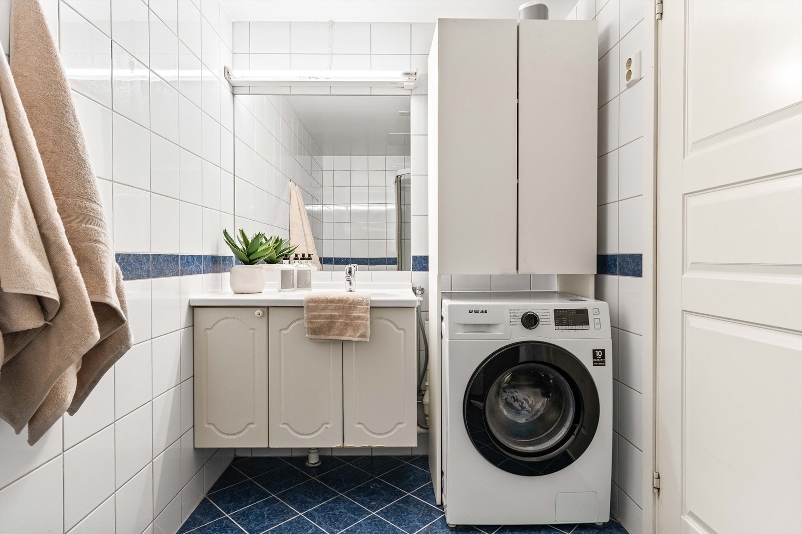 På badet er det god oppbevaringsplass i servantinnredning, samt opplegg for vaskemaskin. Galleribilde