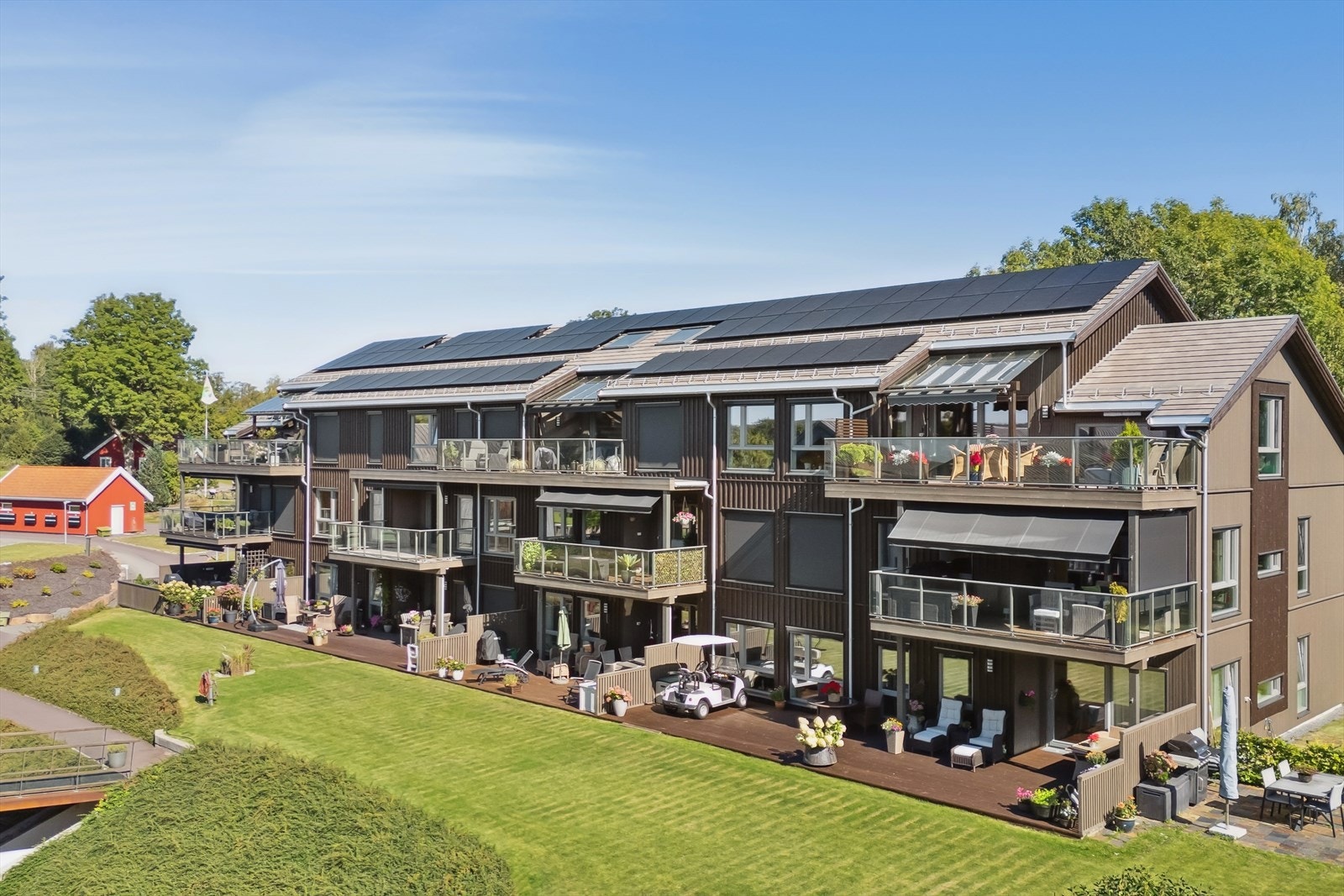 Moderne leilighetsbygg med store terrasseflater og solcellepaneler på taket. Galleribilde