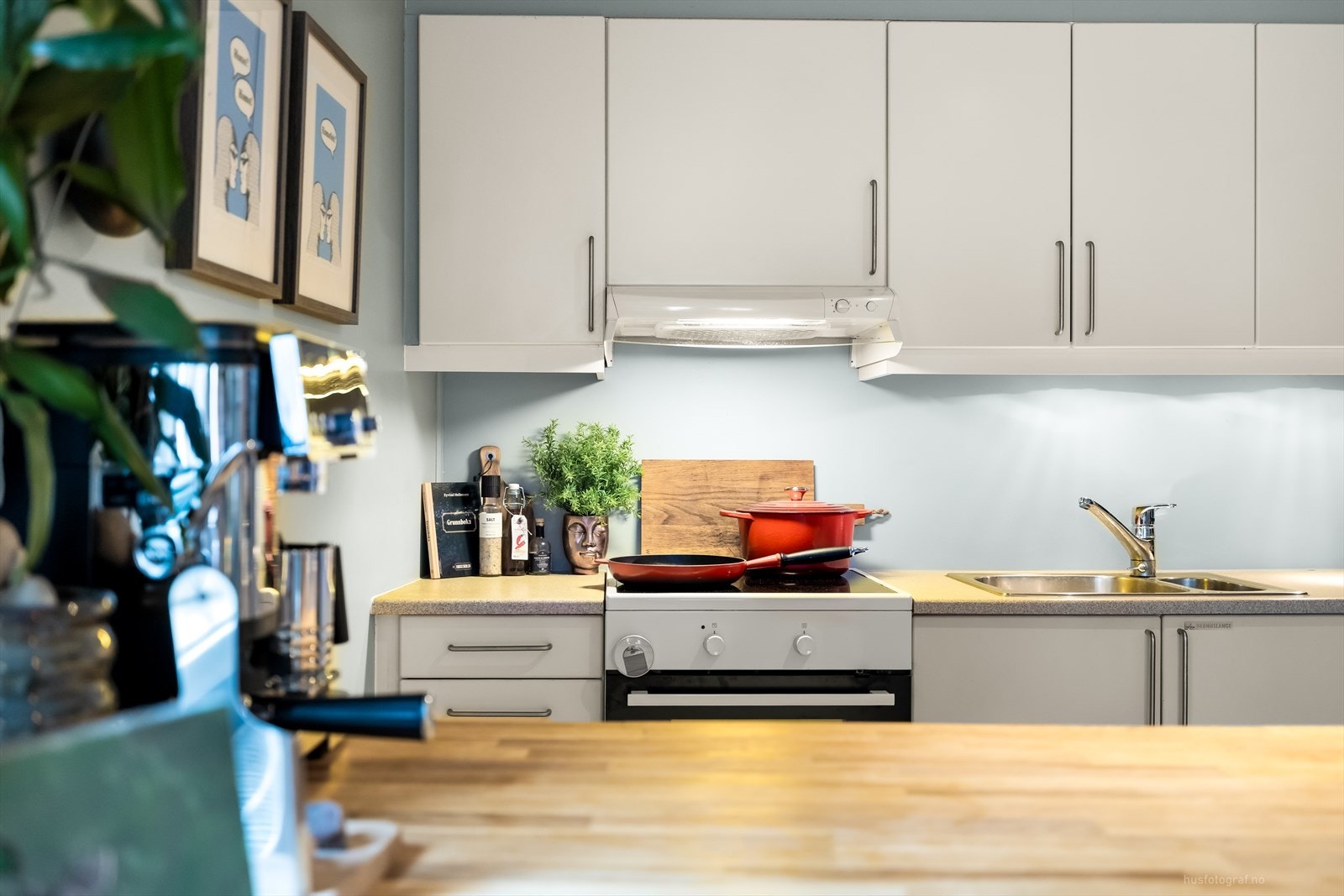 Klassisk kjøkkeninnredning med overflater som består av hvite glatte fronter og benkeplate av laminat. Galleribilde