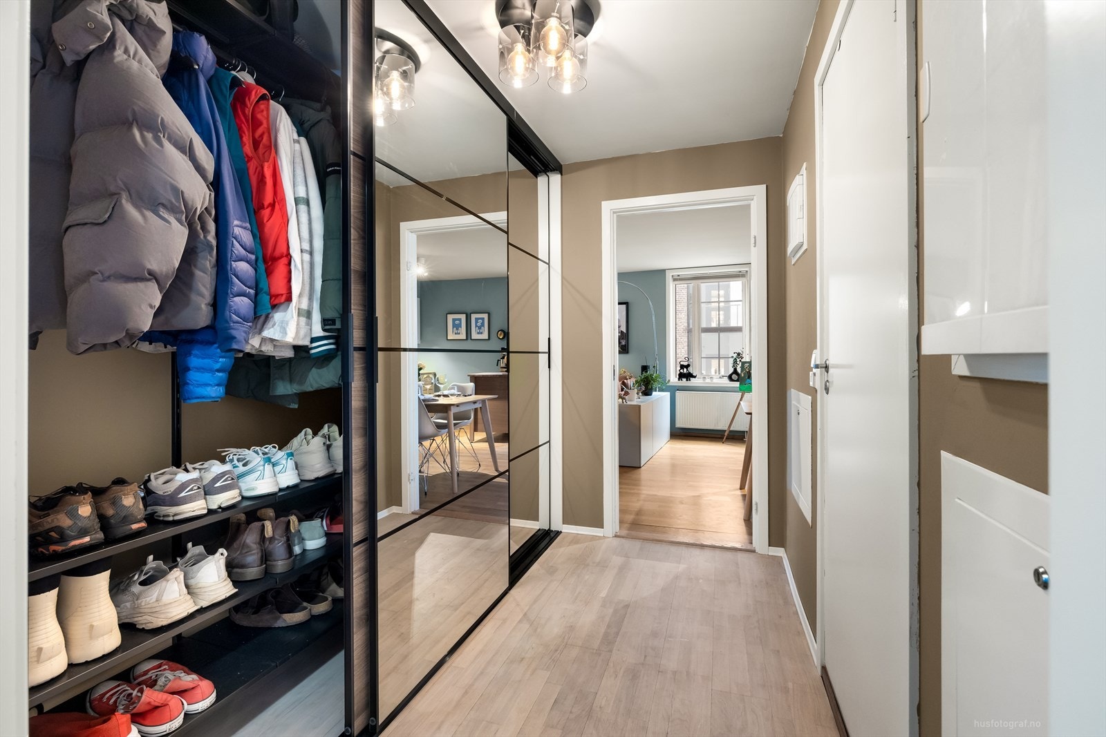 Velkommen inn til en romslig entré med god plass til oppheng for yttertøy og til å sette ifra seg sko, i skyvedørsgarderobe noe som gjør det enkelt å holde orden i inngangspartiet. Galleribilde