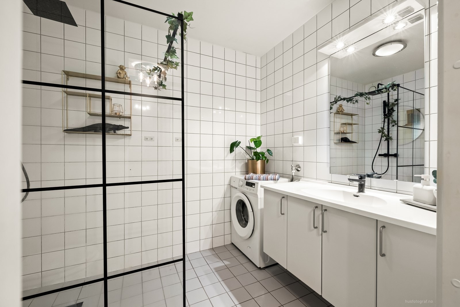 Badet er innredet med nedfelt servant med rom for oppbevaring i underskap, speil med belysning, toalett og dusjhjørne med regndusjarmatur. Galleribilde