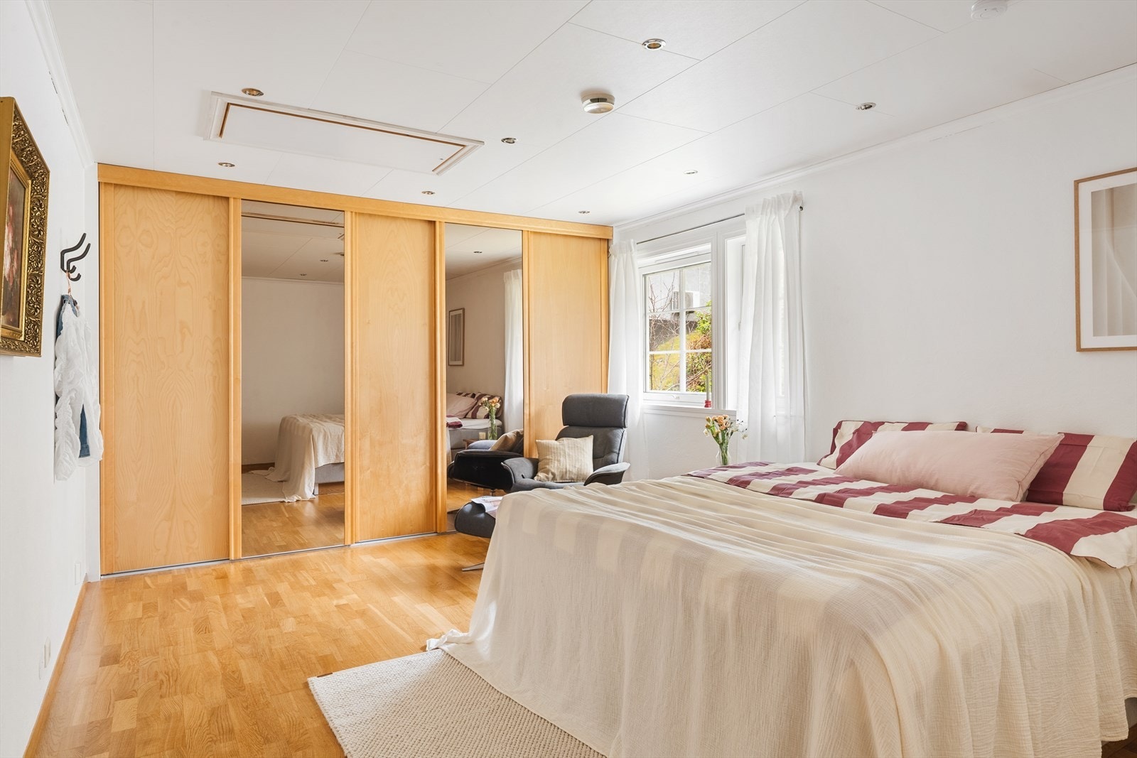 Romslig og flott soverom med skyvedørsgarderobe og downlights i takhimling Galleribilde