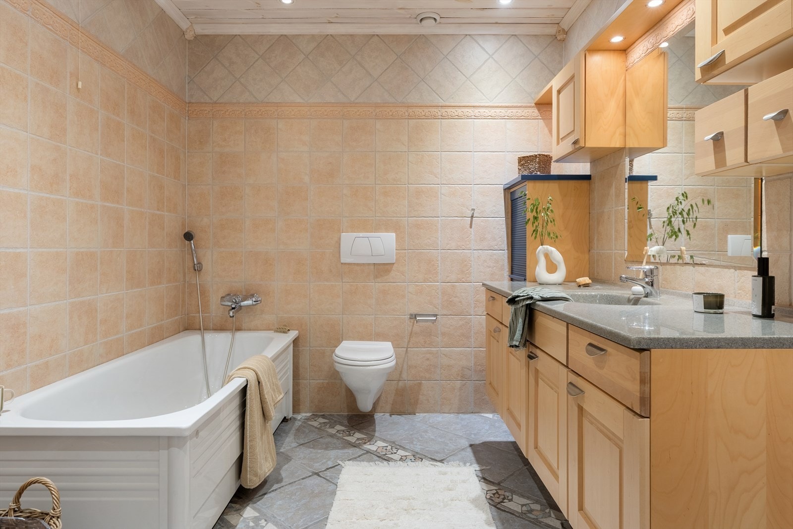 Helfliset baderom/wc i 1.etasje - Gulvvarme, badekar, fin innholdsrik baderomsinnredning og vegghengt wc Galleribilde