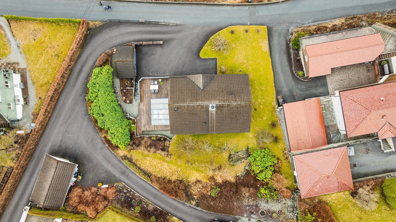 Oversiktsbilde over eiendommen - Pent opparbeidet og selveiet tomt - Fin hage og beplantning Galleribilde