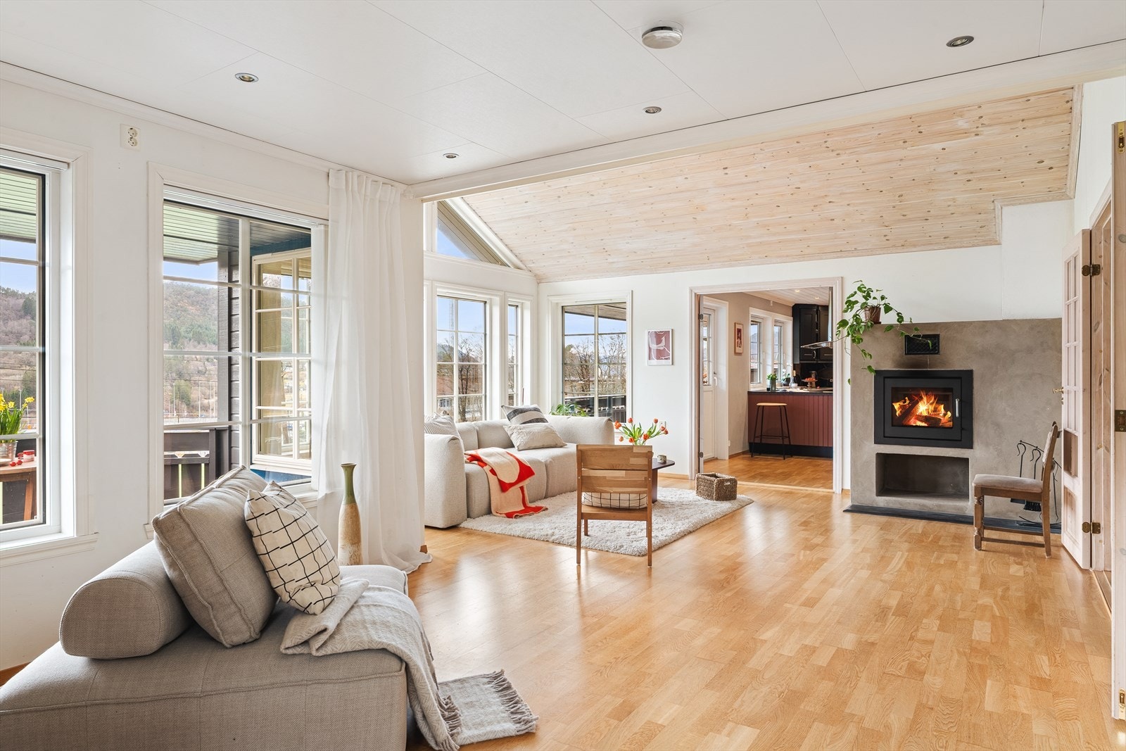 Romslig og pen stue med moderne peisovn, downlights og utgang til solrik terrasse Galleribilde