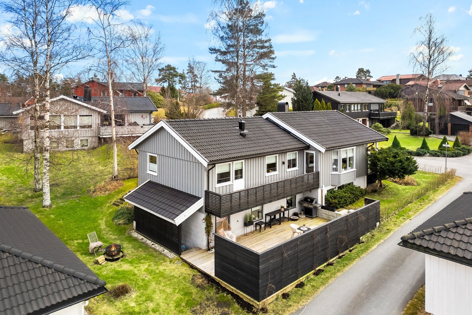 Et rolig og trygt nabolag, hovedsakelig bestående av eneboliger. Fasade i kveldsbelysning. Galleribilde