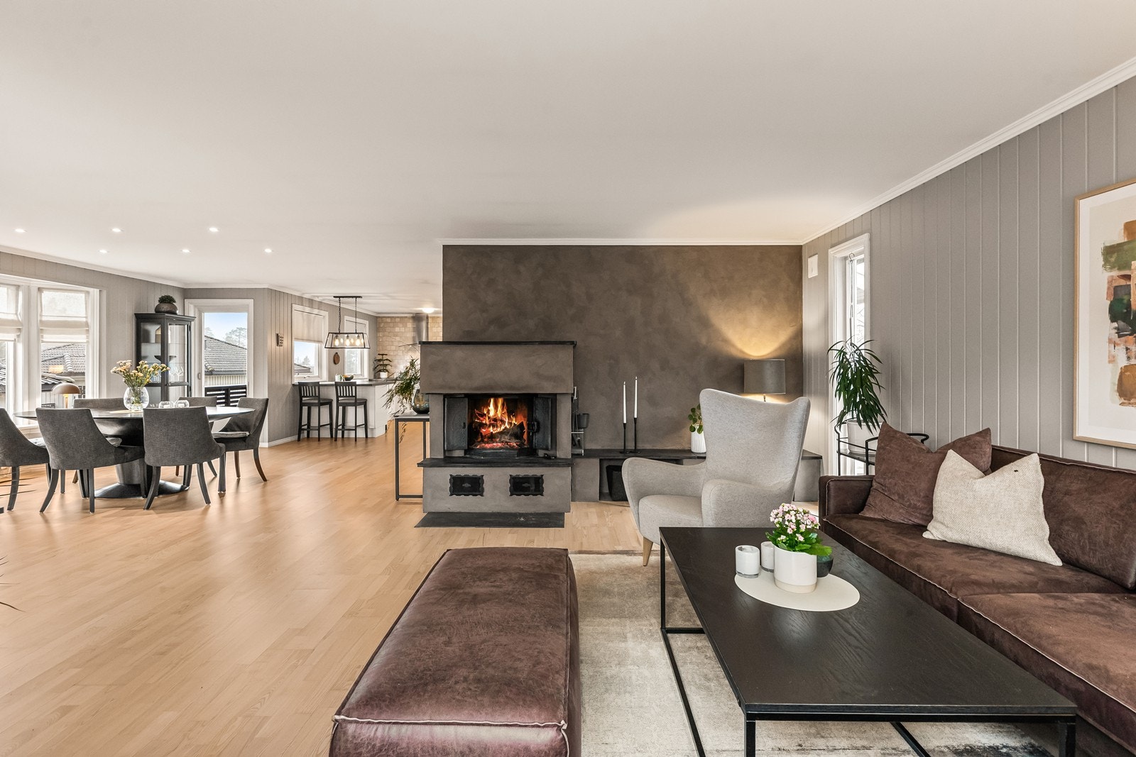 Stuen er sentrert rundt en peis med innsats i støpejern, som gir både varme og en hyggelig stemning. Galleribilde