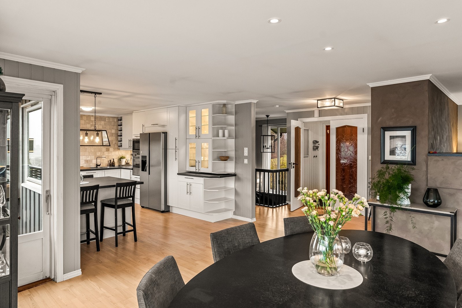 Første etasje har en gjennomgående åpen planløsning, etablert i 2008, som skaper en sosial og luftig atmosfære mellom stue, spisestue og kjøkken. Galleribilde