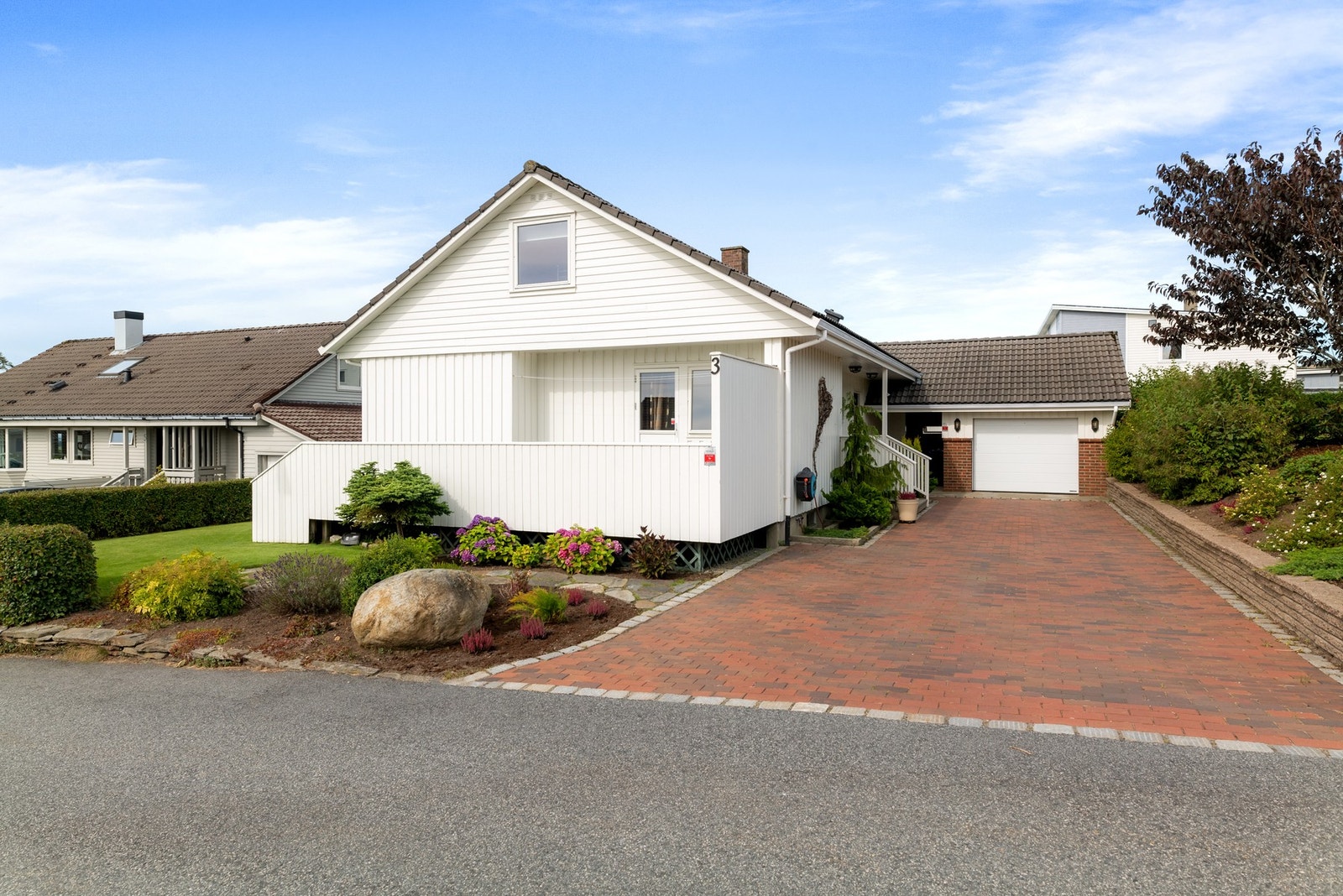 Boligen byr på en solrik tomt, romslig gårdsrom og garasje. Galleribilde