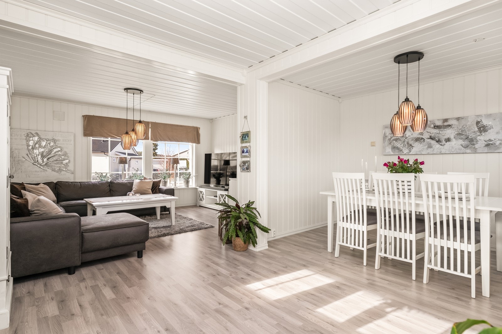 Stuen har god plass til både sofagruppe og spisegruppe. Overflatene består av gjennomgående laminat på gulv og panel på vegger. Galleribilde