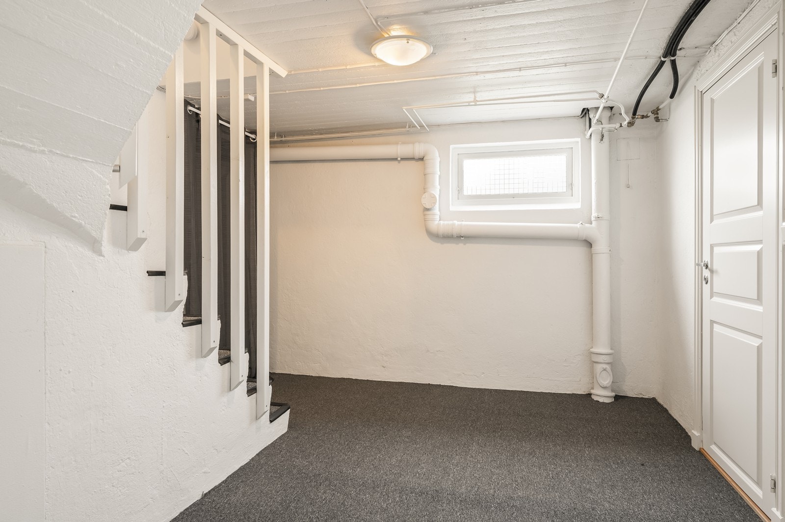 Kjelleren inneholder blant annet to soverom, bad og boder. Trappen ned har teppe i trinnene. Galleribilde