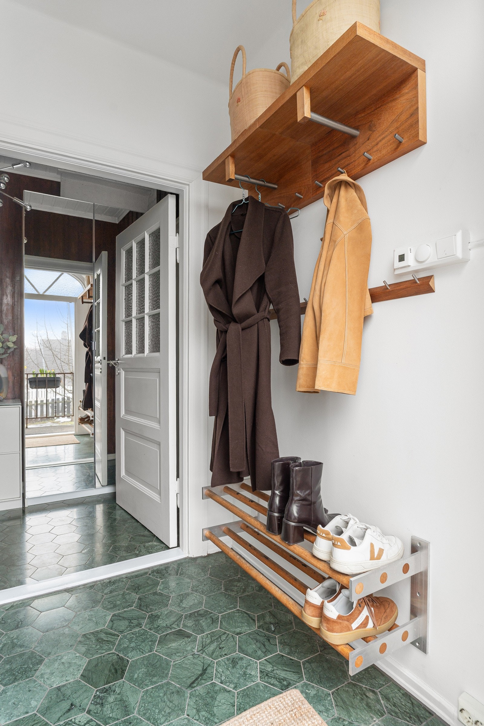 Velkomme inn! Lys og innbydende entré med flislagt gulv og klassiske detaljer. Her er det god plass til å henge fra seg klær og diverse, samt å etablere garderobeskap. Galleribilde