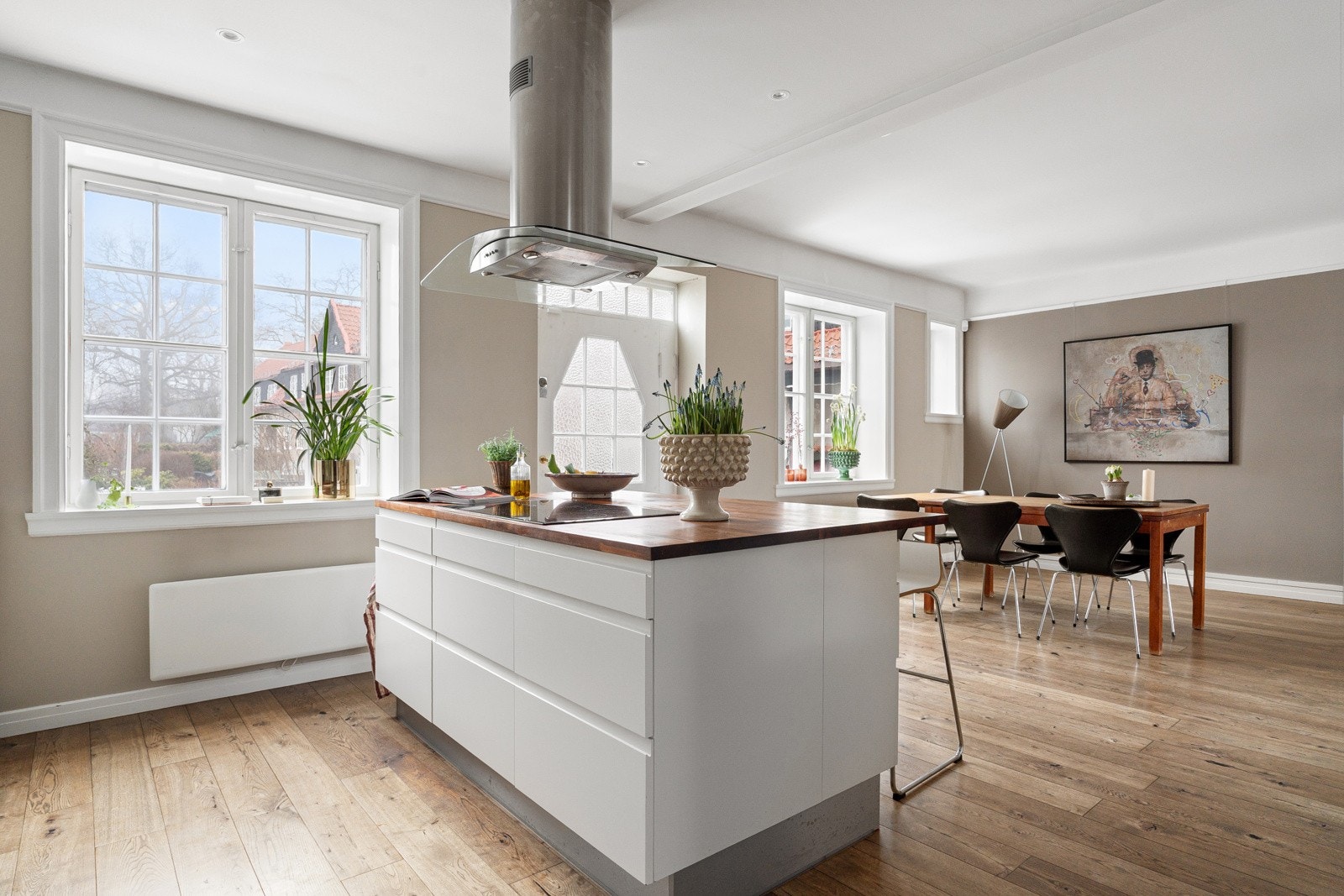 Hyggelig åpent kjøkken med store, klassiske vindusflater på rekke og rad med fin utsikt mot havebyen og bakhagen. Galleribilde
