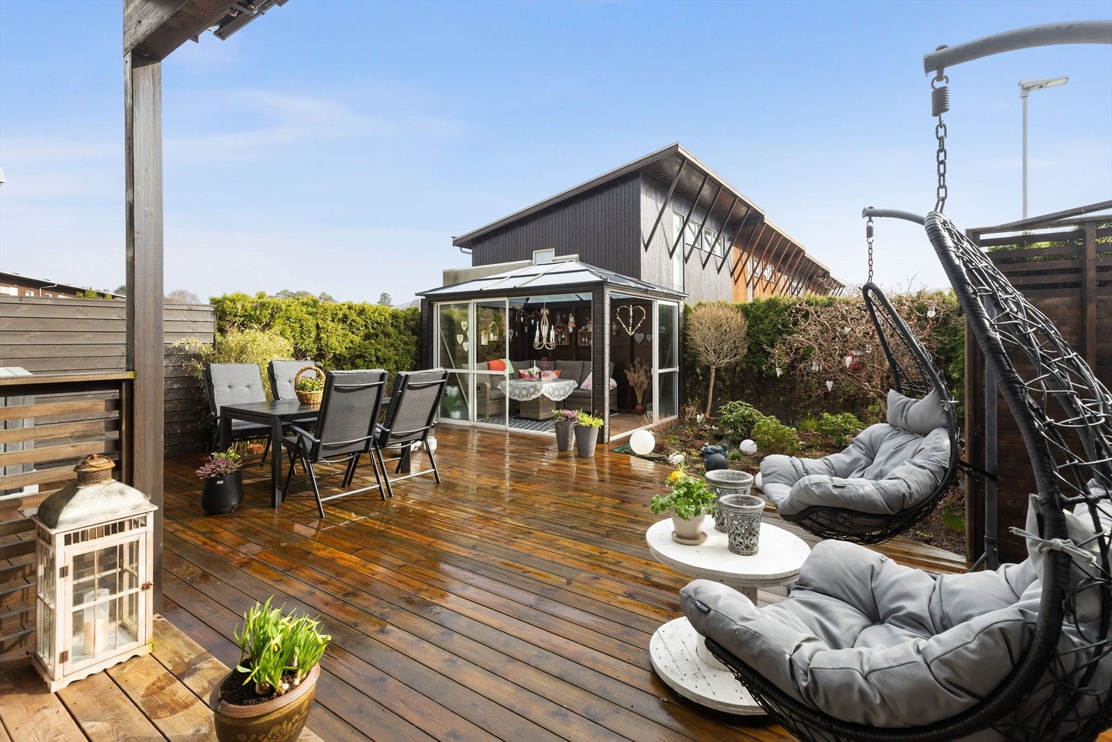 Romslig terrasse med plass til flere sittesoner i tillegg til hagestuen Galleribilde