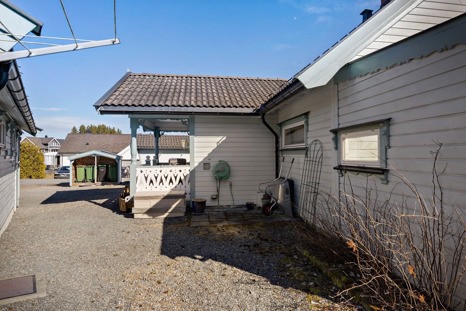 Gruset innkjørsel med plass til biler og sykler. Galleribilde