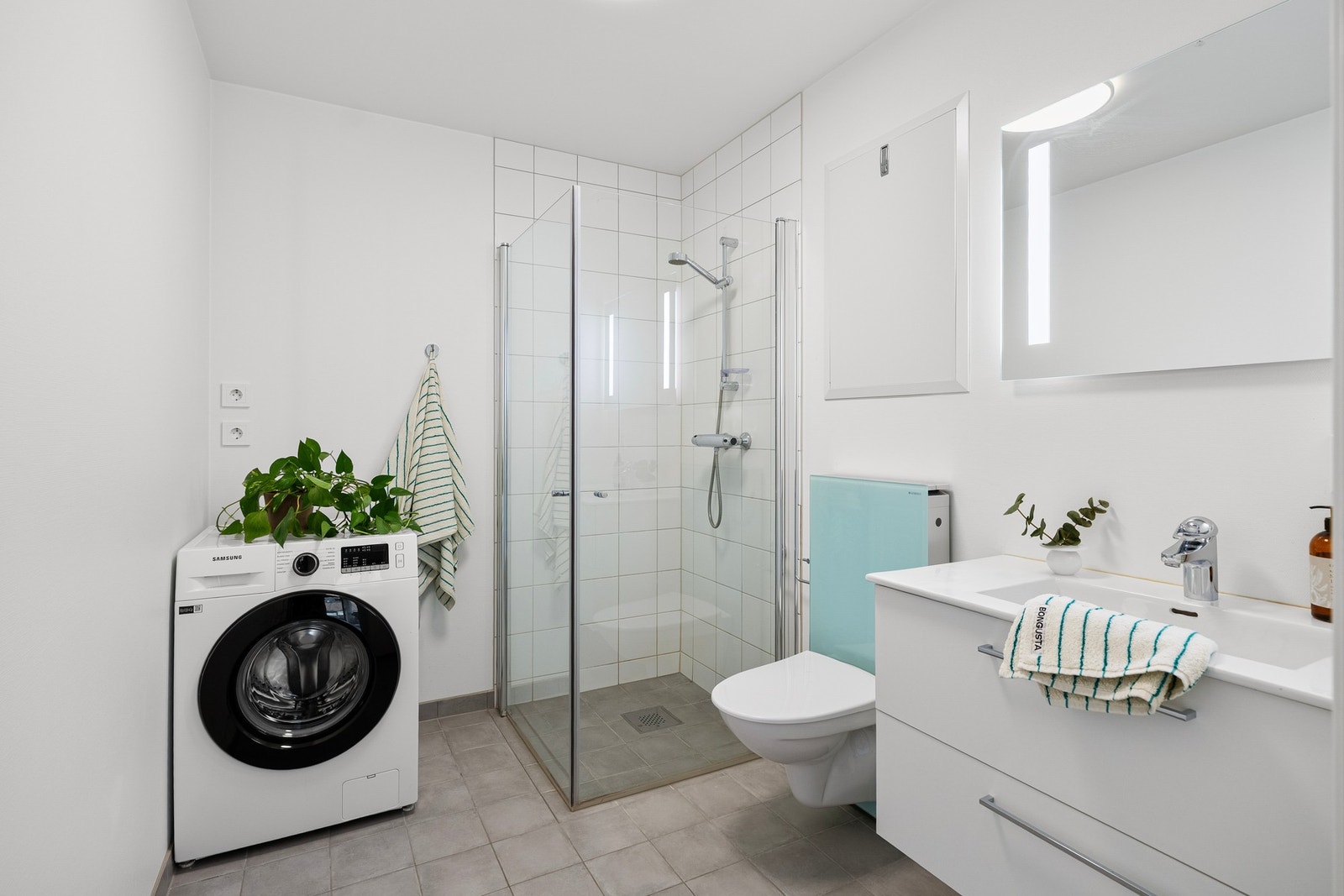 Leiligheten har et romslig og delikat bad med lyse overflater som gir et rent og moderne uttrykk. Galleribilde