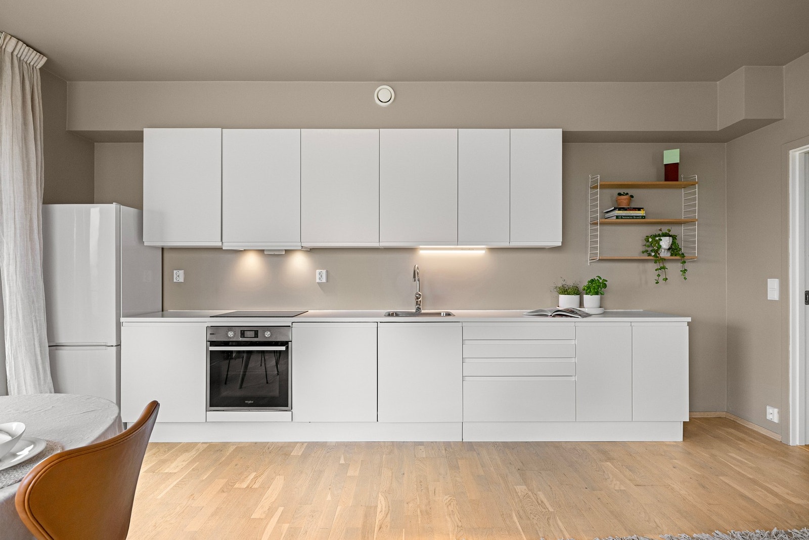 Hvitevarene inkluderer kjøleskap, integrert oppvaskmaskin, integrert platetopp og stekeovn. Galleribilde