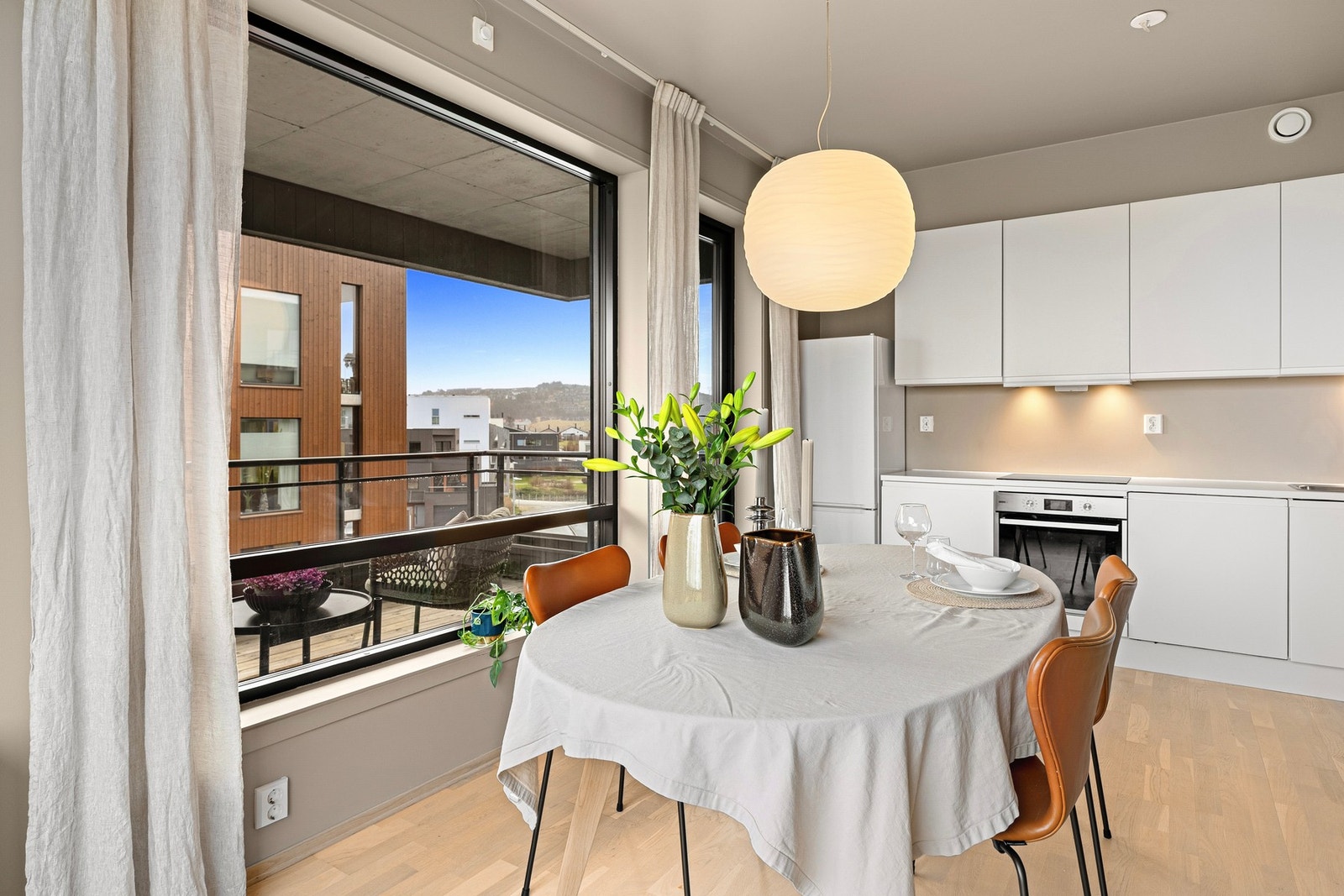 Leiligheten har et moderne og tiltalende kjøkken med stilrene, hvite og glatte fronter som gir et tidløst uttrykk. Galleribilde