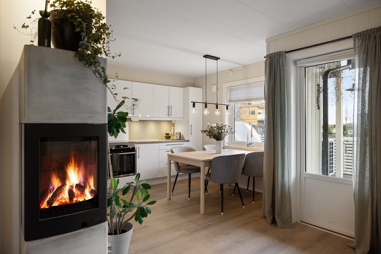 Overflater i lyse farger og laminat på gulvet. Dør ut til terrassen. Galleribilde