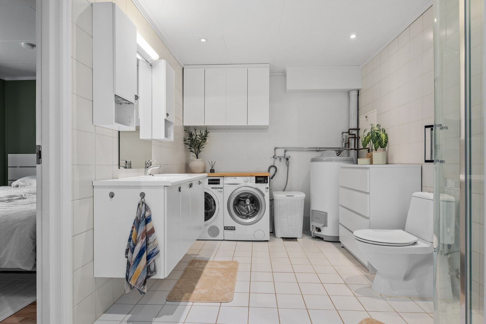 Badet i 1. etasje er på ca. 9 kvm, og har elektrisk varme i det flislagte gulvet. Her har du uttak til vaskemaskin og plass til tørketrommel. Galleribilde