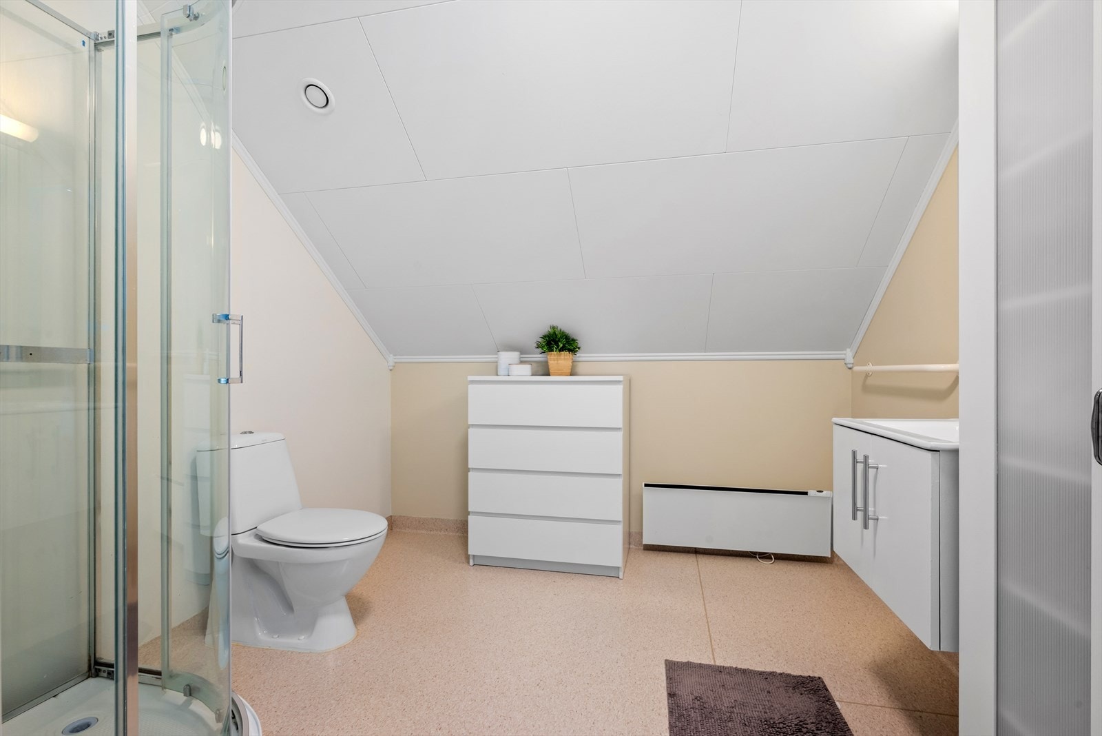 Badet i loftsetasjen har toalett, dusjkabinett og panelovn på veggen. Galleribilde