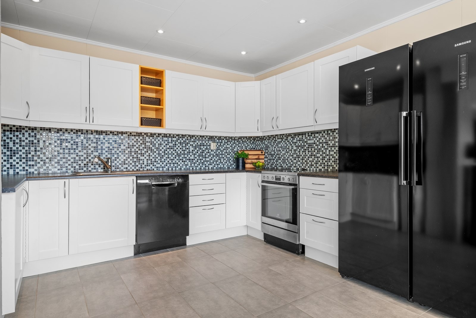 Kjøkkenet har et stilrent og pent design med god skap- og benkeplass. Galleribilde