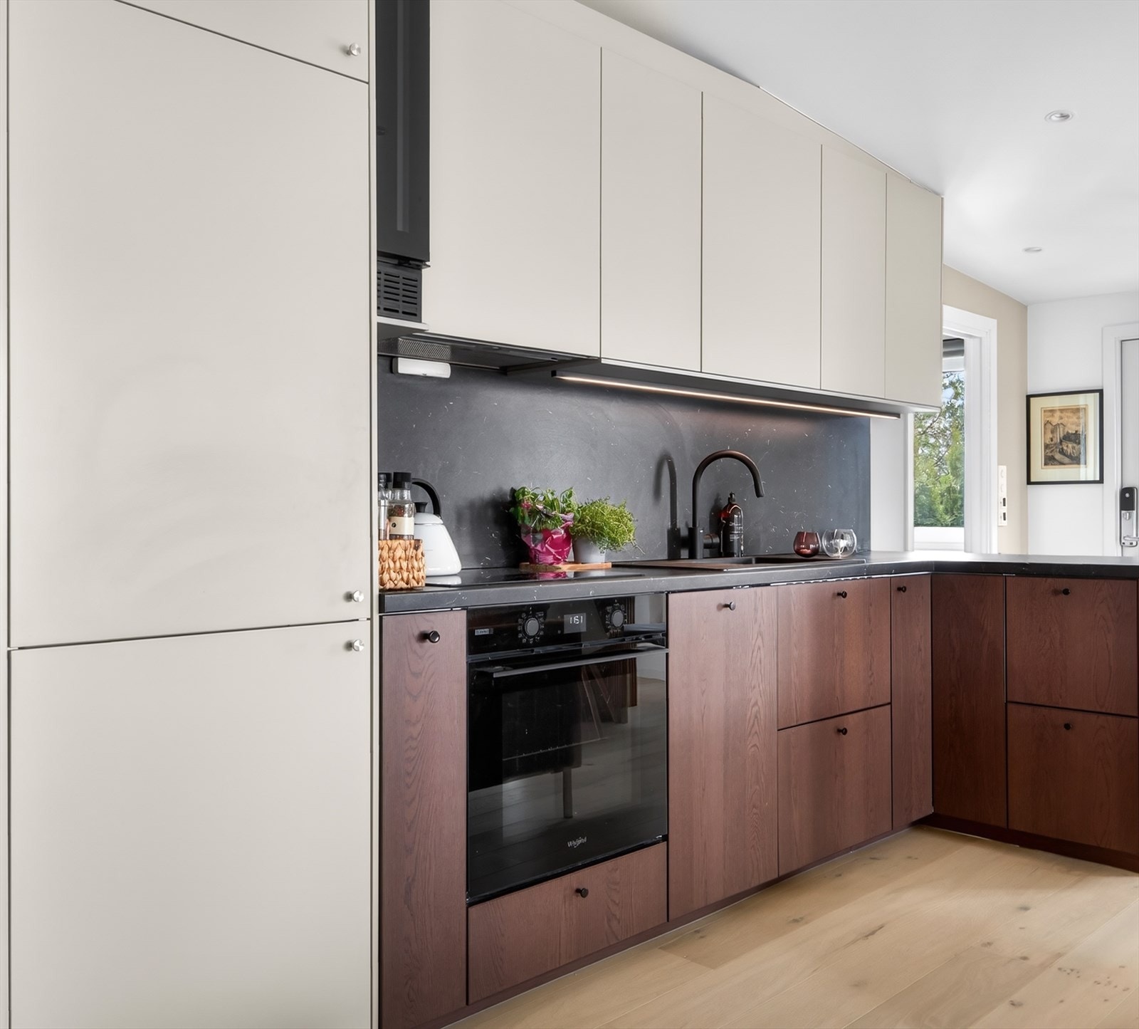 Rålekkert kjøkken fra IKEA med vinskap og diverse integrererte hvitevarer. Galleribilde