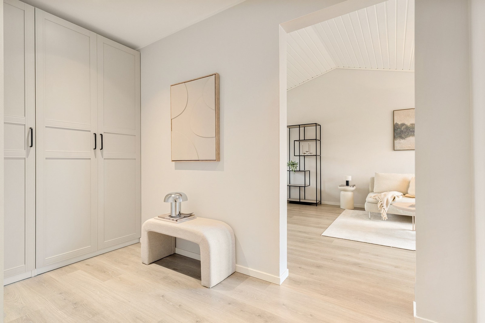 Leilighetens gang/hall er romslig og lys med flotte profilerte garderobeskap. Galleribilde