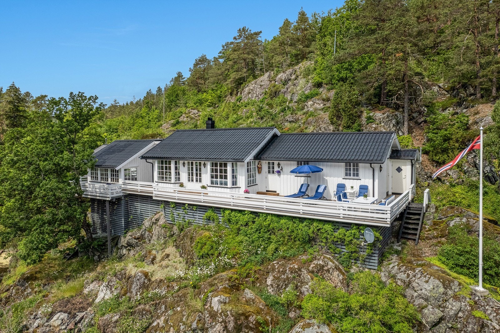 Terrassen strekker seg rundt hele hytta og gir rikelig med plass til spiseplasser, solstoler og loungegrupper. Galleribilde