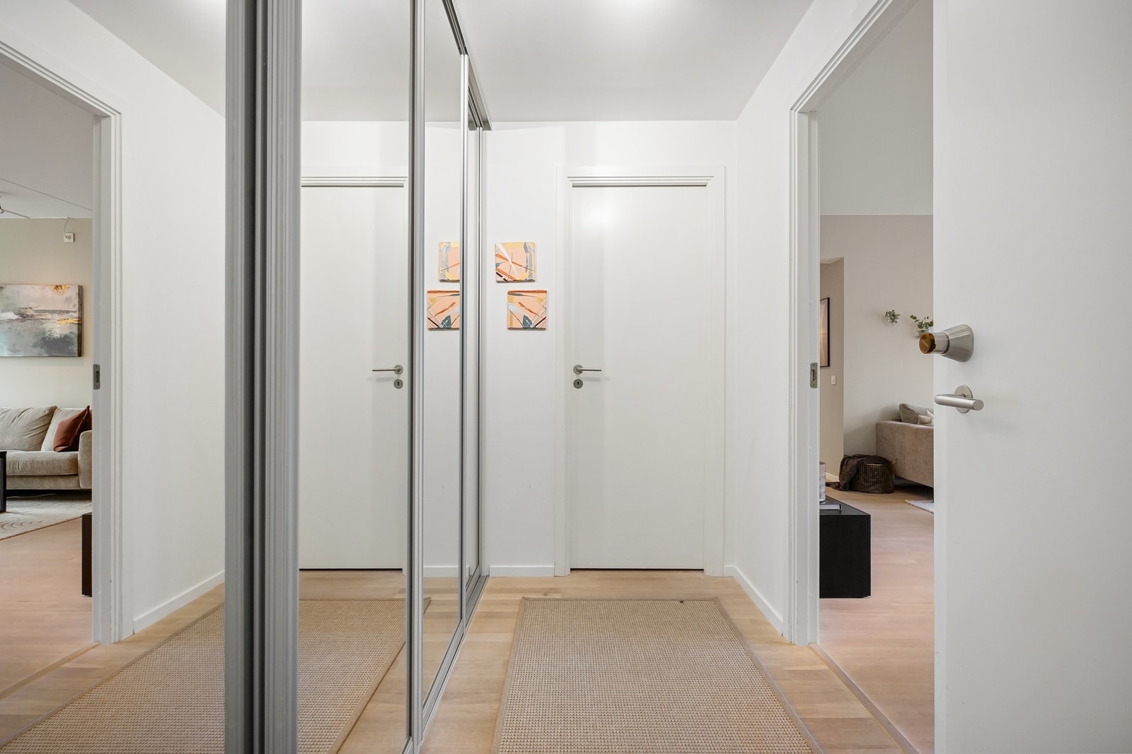 Innbydende inngangsparti med god plass til yttertøy og sko i en praktisk skyvedørsgarderobe med glassdører Galleribilde