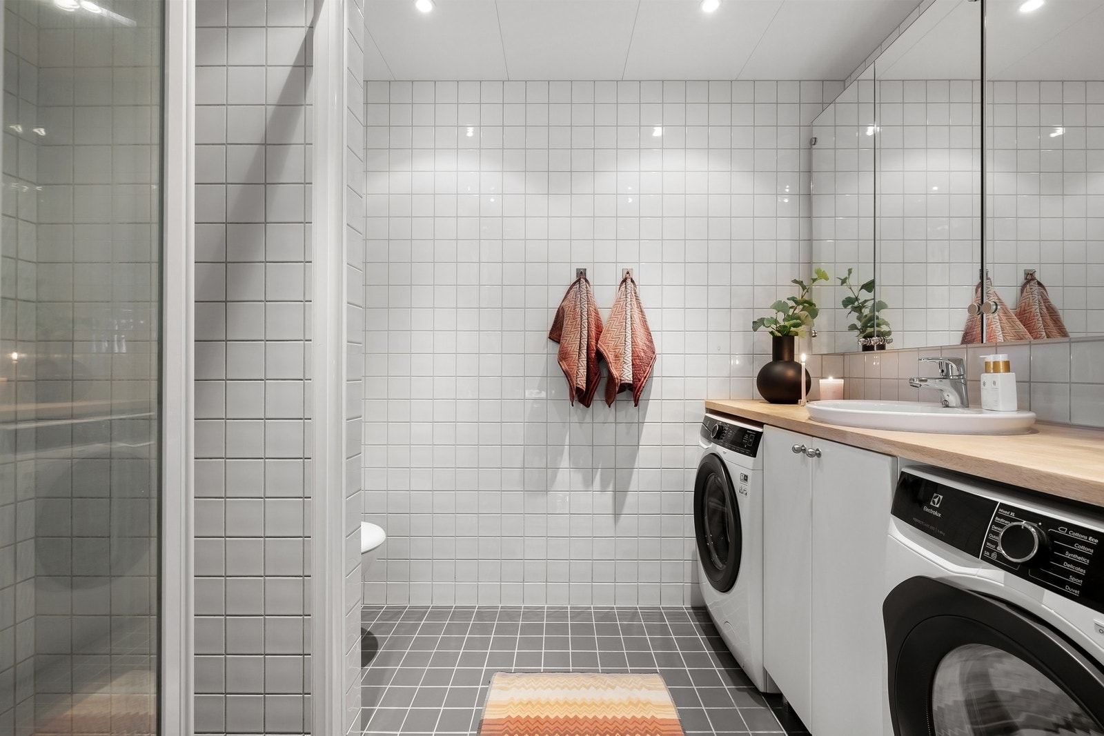 Videre får du et moderne kabinbad, romslig med gode løsninger. Baderommet er praktisk utformet med praktisk heldekkende benkeplate med servant, som gir rom for både oppbevaring, vaskemaskin og tørketrommel på badet Galleribilde